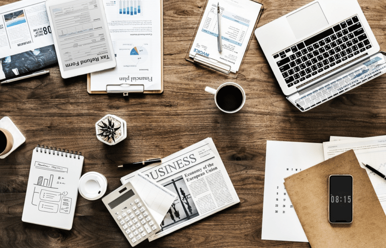 Office desk with business sale agreement papers, laptop, calculator, coffee, and financial documents in Australia.