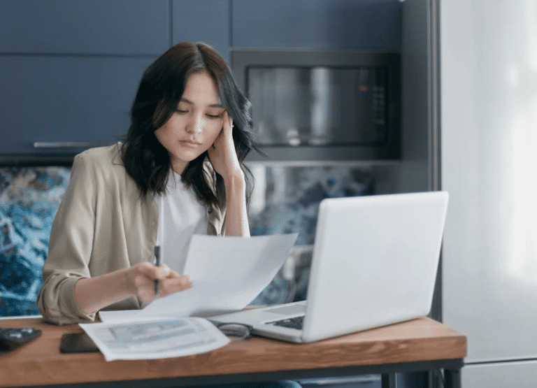 Woman reviews documents at desk, highlighting the legal considerations of leaving your business with Australia law firm guidance.