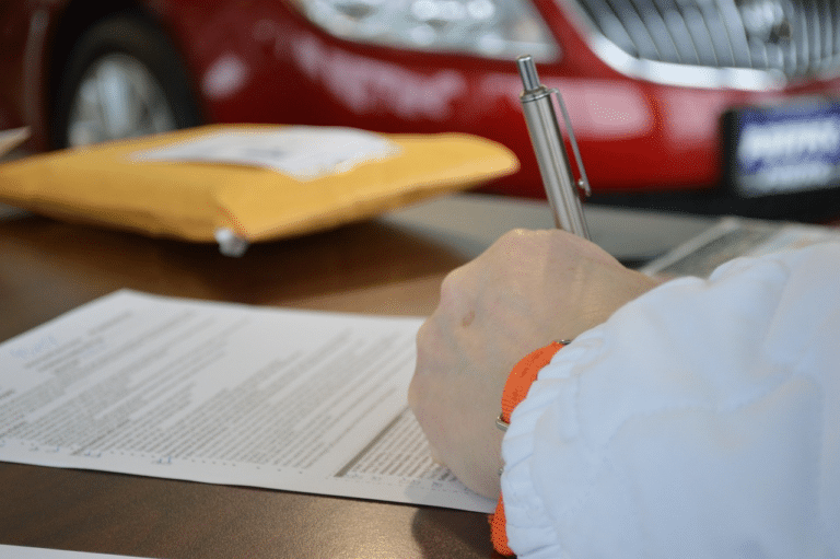 Close-up of a person signing legal documents, highlighting requirements for purchasing a childcare center in NSW.