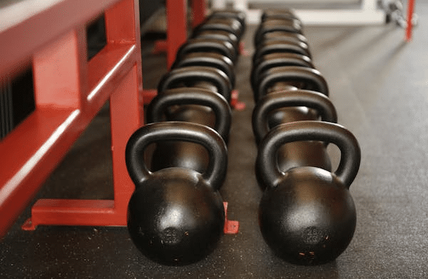 Rows of black kettlebells in a gym, representing legal requirements for buying a gym in NSW.