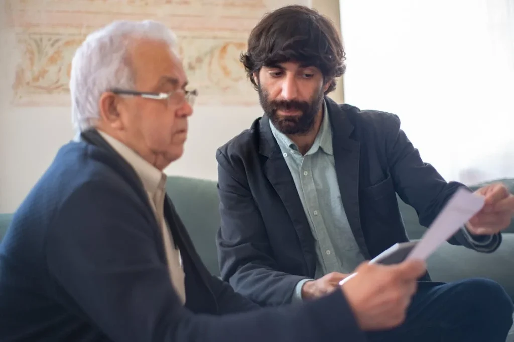 Two men reviewing documents, symbolizing "How to Buy an Accounting Practice: A Comprehensive Legal and Commercial Guide.