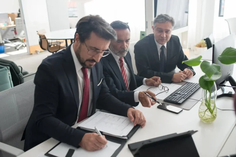 Businessmen in a meeting discussing recovery of bank guarantees in NSW commercial transactions, referencing a legal payment guide.