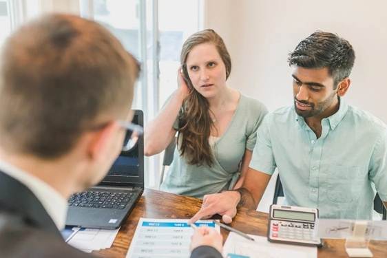 Business owners discussing selling a business with stock, reviewing a comprehensive guide with an advisor.