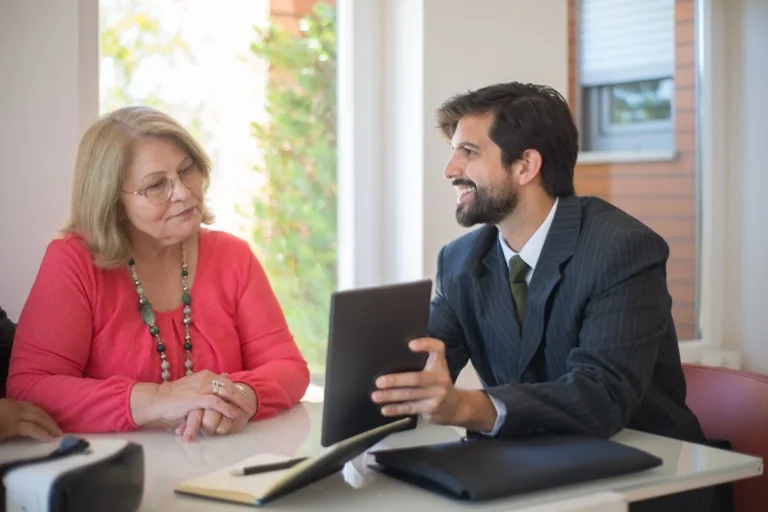 Man and woman discussing essential legal considerations before buying a franchise in NSW, seated at a table.